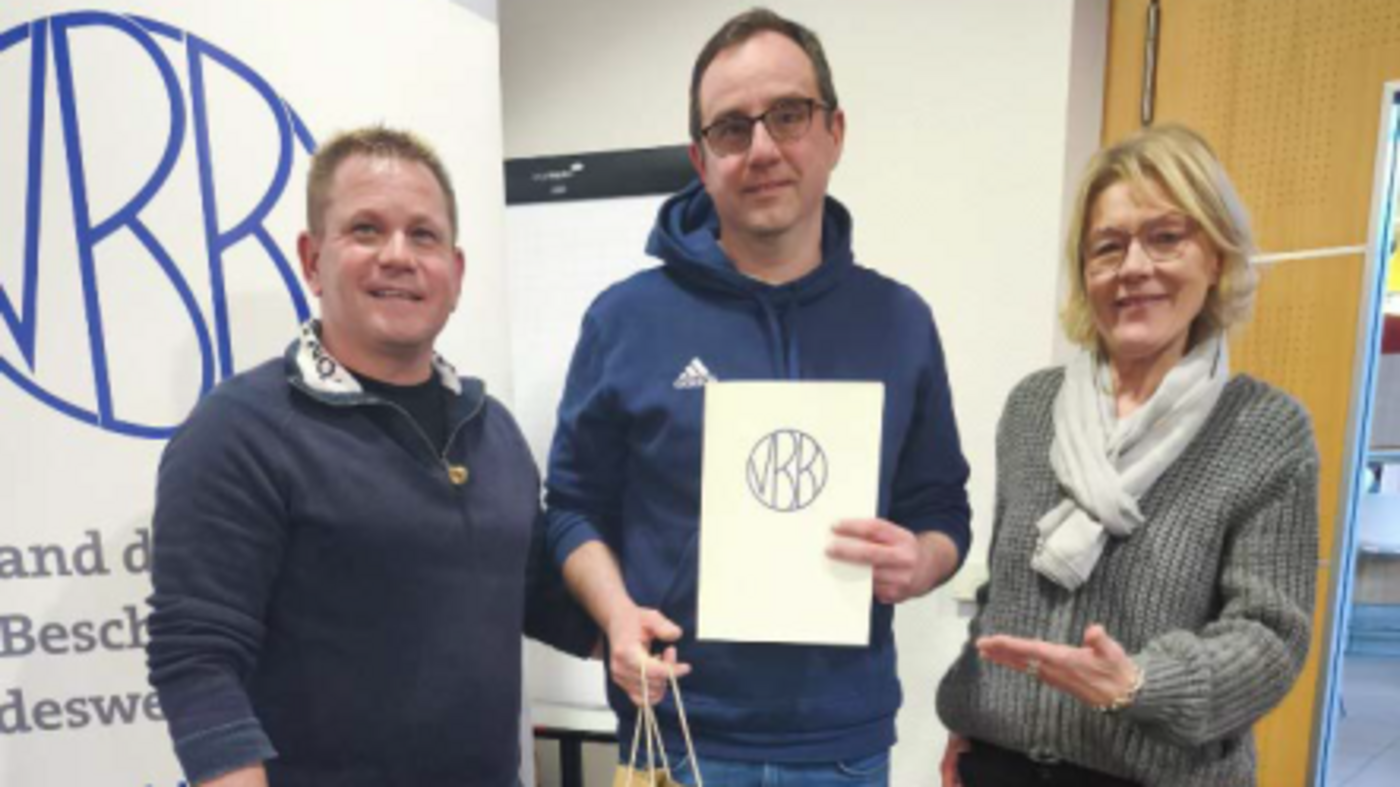 20260126_MV_Mosbach Ehrung für Marc Grasi (Mitte) für 25 Jahre Mitgliedschaft im VBB mit der Ehrennadel in Gold. Die Auszeichnung wurde überreicht durch Karin Voit (rechts) vom Landesverband und den Vorsitzenden der Standortgruppe Mosbach Holger Frank (links) 20260126_MV_Mosbach